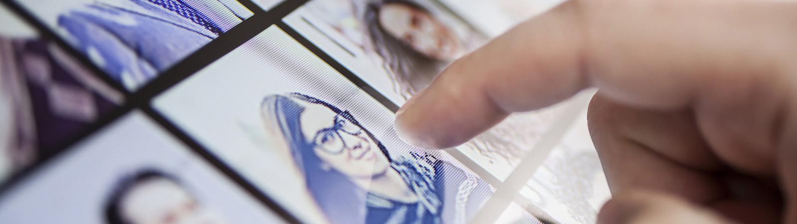 Finger tippt auf Person auf Bildschirm
